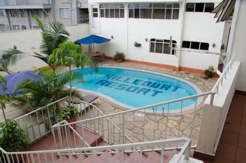 an external view of a building with a swimming pool at Hillcourt Resort and Spa in Nakuru
