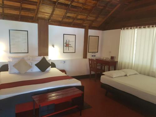 ein Hotelzimmer mit zwei Betten und einem Tisch in der Unterkunft Petit Elephant in Cherai Beach