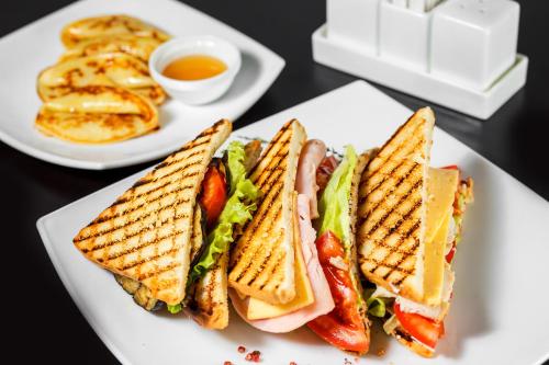 a white plate with a sandwich and some fries at Hotel Khalif in Tomsk