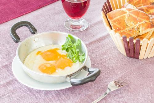 a bowl of eggs and a basket of bread and a glass of wine at Hotel Dosco in Van
