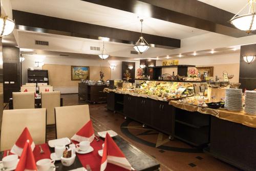 a restaurant with a buffet line with tables and chairs at Hotel Prahova Plaza in Ploieşti