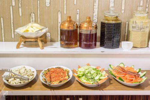 a shelf with four bowls of different types of food at Hotel Dosco in Van