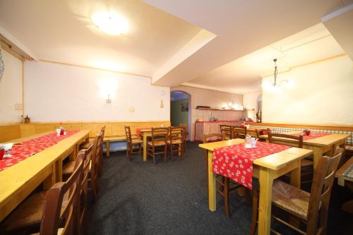 an empty restaurant with wooden tables and chairs at Vila Edelweiss Rooms&App Kranjska Gora in Kranjska Gora