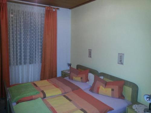 1 dormitorio con 1 cama con almohadas coloridas en Rottl-Sepp Renoth Karoline, en Berchtesgaden