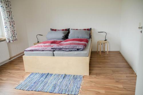 een bed in een kleine kamer met een houten vloer bij Ferienwohnung 1 Wildgans in Sagard