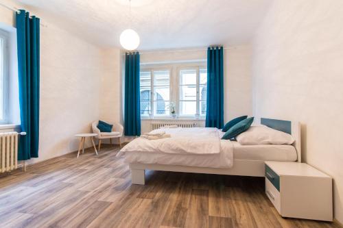 a bedroom with a bed and blue curtains at Karlova Apartment in Prague