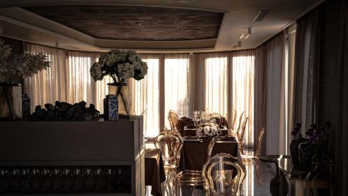 a dining room with a table with a vase of flowers at Hotel Villa Pascucci in Durrës