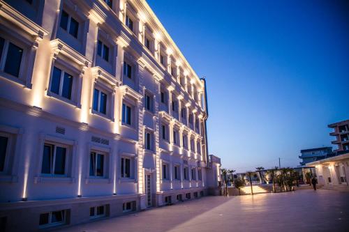 a white building with lights on the side of it at Hotel Villa Pascucci in Durrës
