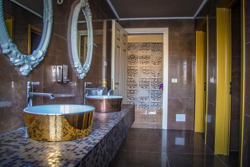 a bathroom with two sinks and two mirrors at Hotel Villa Pascucci in Durrës