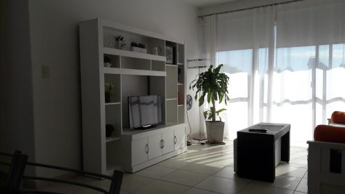 una sala de estar con TV en un armario blanco en Apartamento Plaza San Martin en Concepción del Uruguay