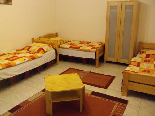 ブダペストにあるErik Apartmentsのベッド3台とテーブルが備わる部屋