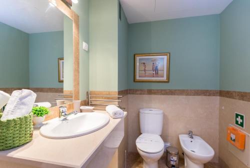 a bathroom with a sink and a toilet and a mirror at Beach View Apartment Litoralmar in Portimão