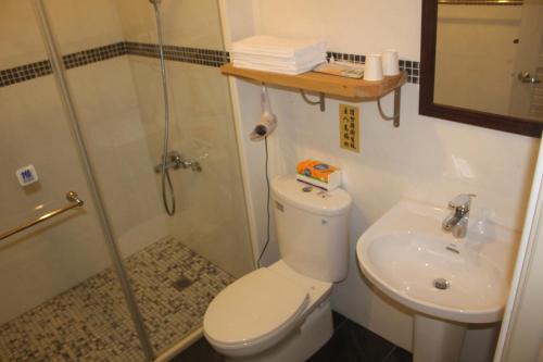 a bathroom with a shower and a toilet and a sink at Katsu B&B in Ji'an