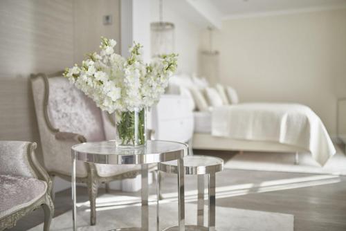 a vase of flowers on a glass table in a living room at PALOMA Průhonice in Pruhonice