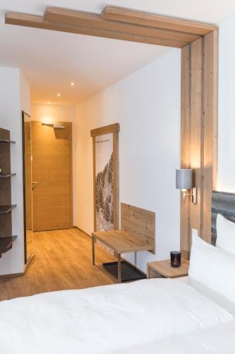a bedroom with a bed and a bench and a door at The Ischgl Lodge in Ischgl