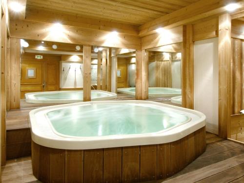 a large jacuzzi tub in a room with wooden walls at Le Chalet des Cimes in Belle Plagne