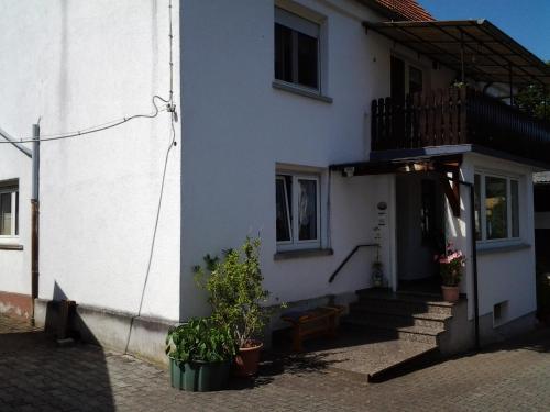 uma casa branca com uma escada e uma varanda em Ferienwohnung bei Michels em Ober-Kinzig