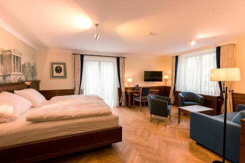 a hotel room with a bed and a desk at Hotel & Gaststätte zum Erdinger Weißbräu in Munich