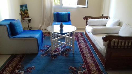 a living room with a couch and a table at Résidence La Galiote in Essaouira