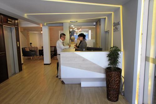 a man and woman standing at a counter in an office at Samana Hotel in Arequipa