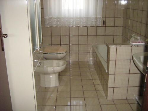 a bathroom with a toilet and a tub and a sink at Villa Violetta in Buseto Palizzolo