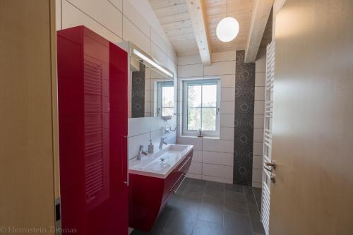 a bathroom with a sink and a red cabinet at Ferienwohnung Schneehase in Turracher Hohe