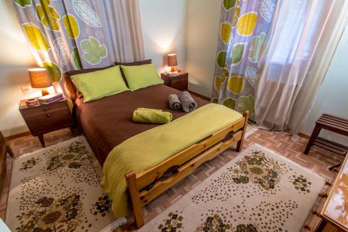 a bedroom with a wooden bed with yellow pillows at Lampreiko in Synikia Mesi Trikalon