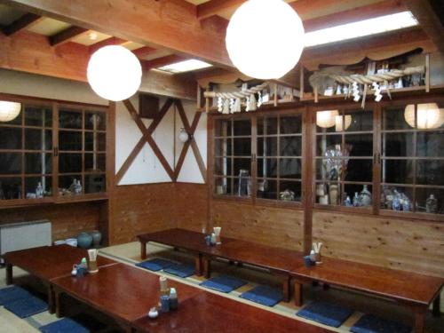 a dining room with wooden tables and chandeliers at Inaka no Yado SAWA in Nozawa Onsen
