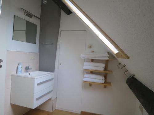 a white bathroom with a sink and a mirror at Ferienwohnungen Haus Hinneres in Schalkenmehren