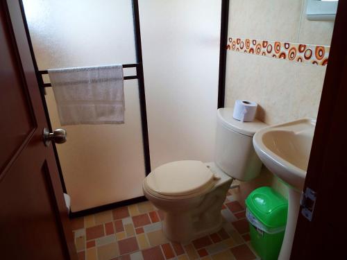 a bathroom with a toilet and a sink at Hotel Campestre Alto Bonito del Quindío in El Cuzco
