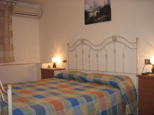 a bedroom with a large bed with a colorful blanket at Villa Violetta in Buseto Palizzolo