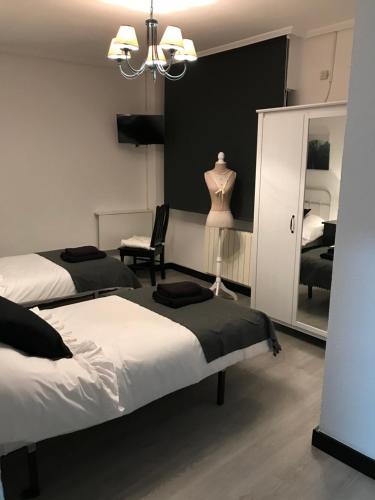 a bedroom with two beds and a dresser and a mirror at Alojamiento El Cantal in Santoña