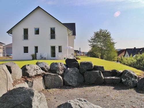 a house with a bunch of rocks in front of it at FeWo WELL in Gladenbach