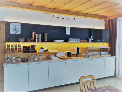 a kitchen with a white counter with a chair at Pension Garni Appartement Ortner in Sankt Johann in Tirol
