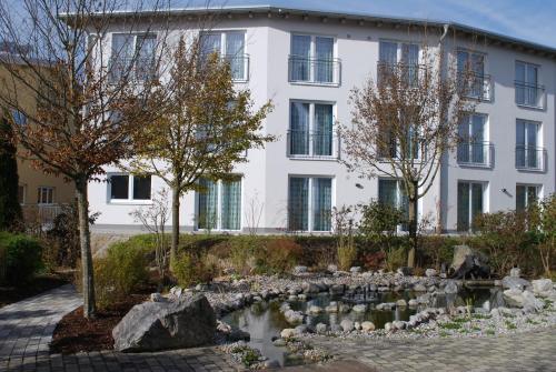 a building with a pond in front of a building at Lichtblick Hotel Garni in Alling