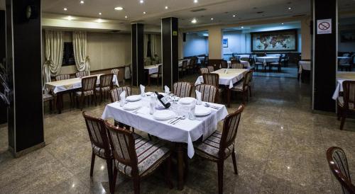 una sala da pranzo con tavoli e sedie in un ristorante di Hotel Atlas a Novi Pazar