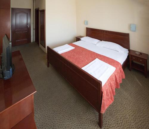 a hotel room with a bed and a television at Hotel Atlas in Novi Pazar