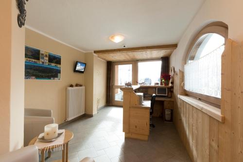 an office with a desk and a table with a window at Hotel Champagne in Livigno
