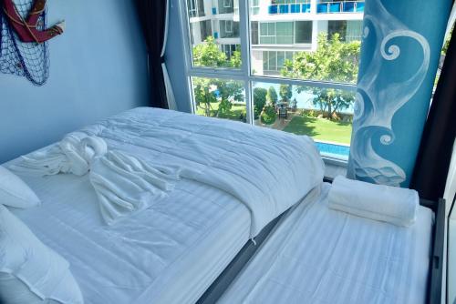 ホアヒンにあるMy Resort Hua Hin E306の窓のある部屋にある白いベッド