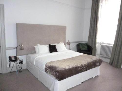 a bedroom with a large white bed with white pillows at Aston Hall Hotel, BW Signature Collection in Sheffield