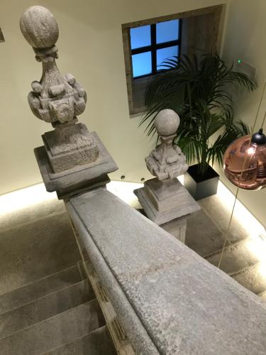 a staircase with three stone vases in a room at Pazo de Mendoza in Baiona