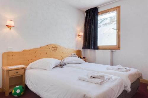 een slaapkamer met een groot wit bed en een raam bij Residence Chalet de l'Adonis in Les Menuires