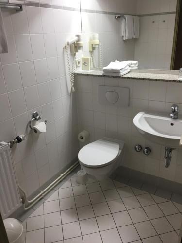 a bathroom with a toilet and a sink at Rügen-Hotel in Sassnitz
