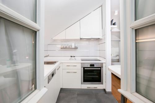 a white kitchen with a sink and a stove at Divota Apartment Hotel in Split