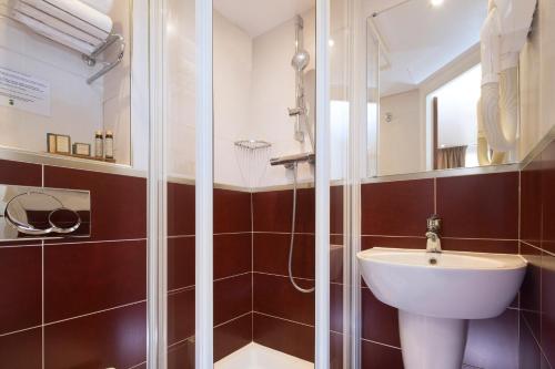 a bathroom with a sink and a shower at Europe Hotel Paris Eiffel in Paris