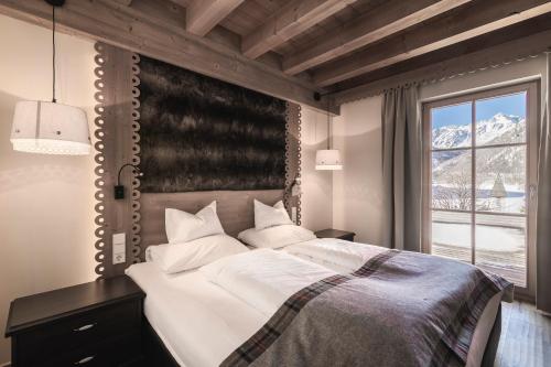 um quarto com uma cama grande e uma janela em Hotel & Chalets Edelweiss em Madonna