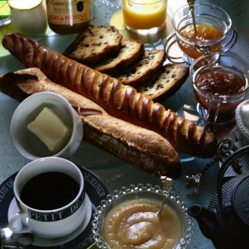 une table avec une assiette de pain et une tasse de café dans l'établissement Chambres d'hôtes La Maison Hippolyte, à Paris
