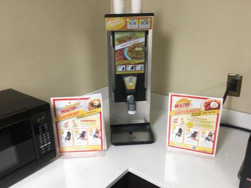 a popcorn vending machine next to a microwave at Super 8 by Wyndham Bedford DFW Airport West in Bedford