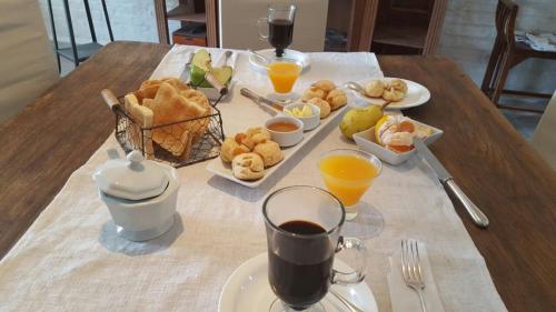 a table with breakfast foods and orange juice on it at Bidieen Inn Uruguay in Carrasco