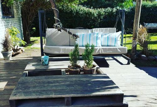 a couch on a swing in a garden at Bidieen Inn Uruguay in Carrasco